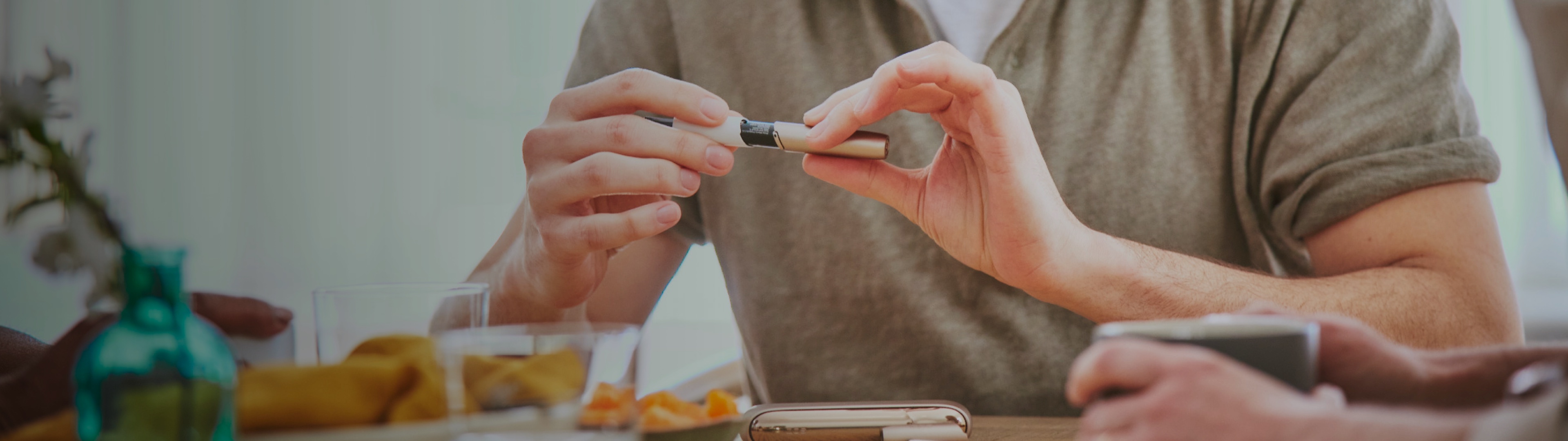 Man removing cap from IQOS Originals Holder